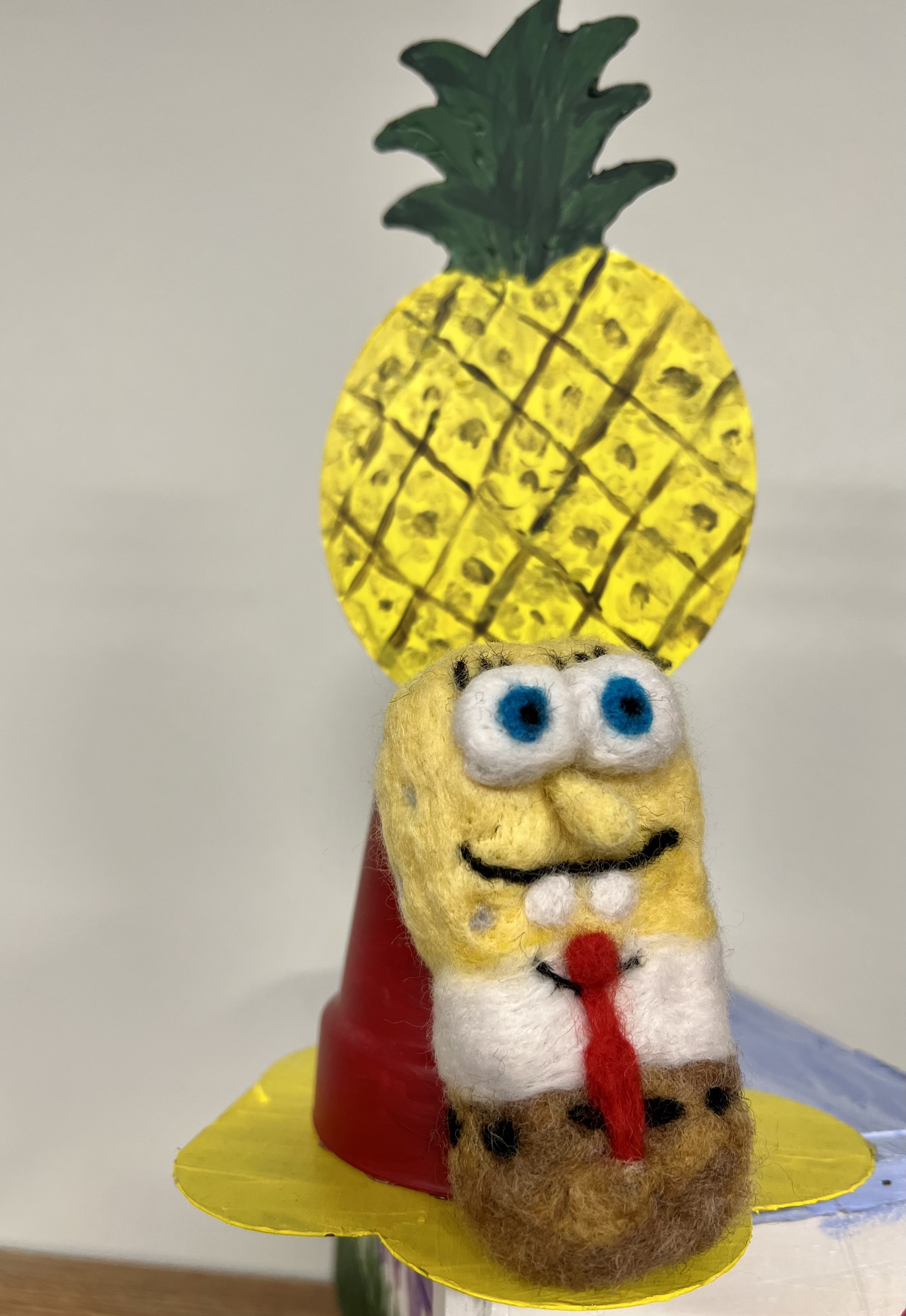 needle felted SpongeBob next to a pineapple