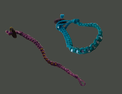 Two macrame bracelets - one teal and one purple - each made with square knots alternating with hex nuts. 