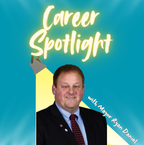 blue background with the words "career spotlight" in a spotlight yellow. A picture of mayor ryan daniel sitting under a spotlight