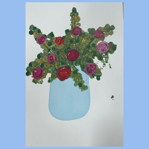 blue vase with greenery and pink and red roses