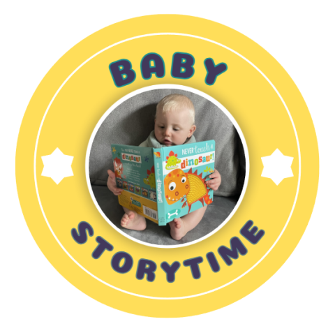 yellow circle with a picture of a baby reading a book in the middle the words baby storytime surrounding the picture with white stars separating the words