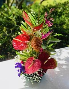floral arrangement featuring red and orange flowers and greenery