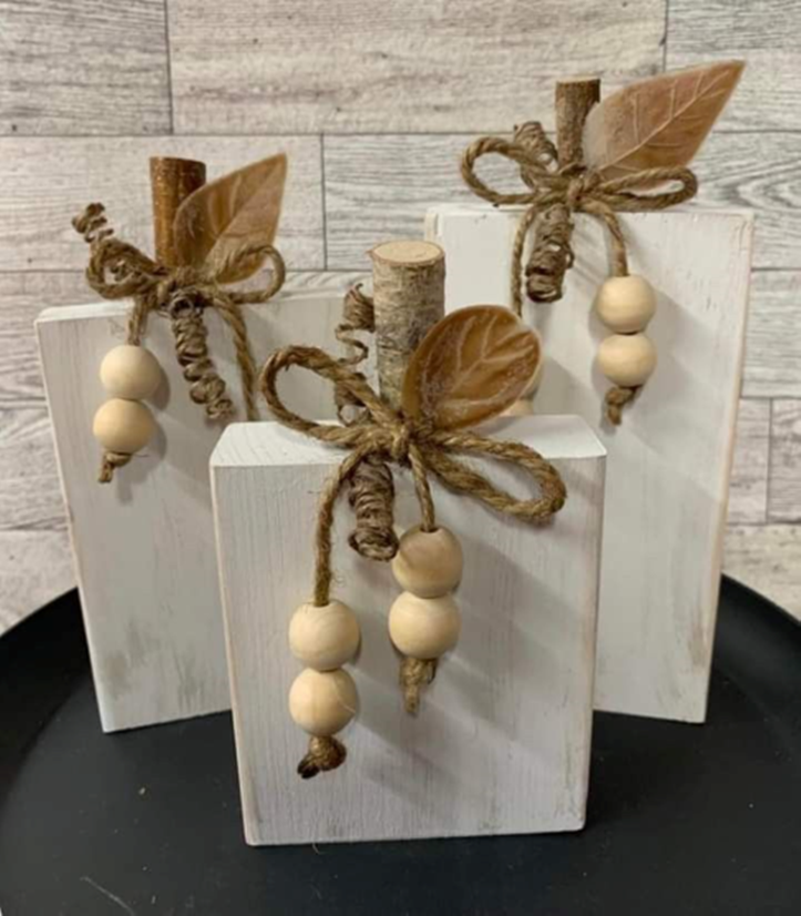 a white block pumpkin with twine and beads