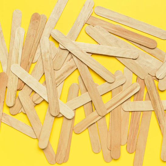 yellow background with a strewn about pile of popsicle sticks